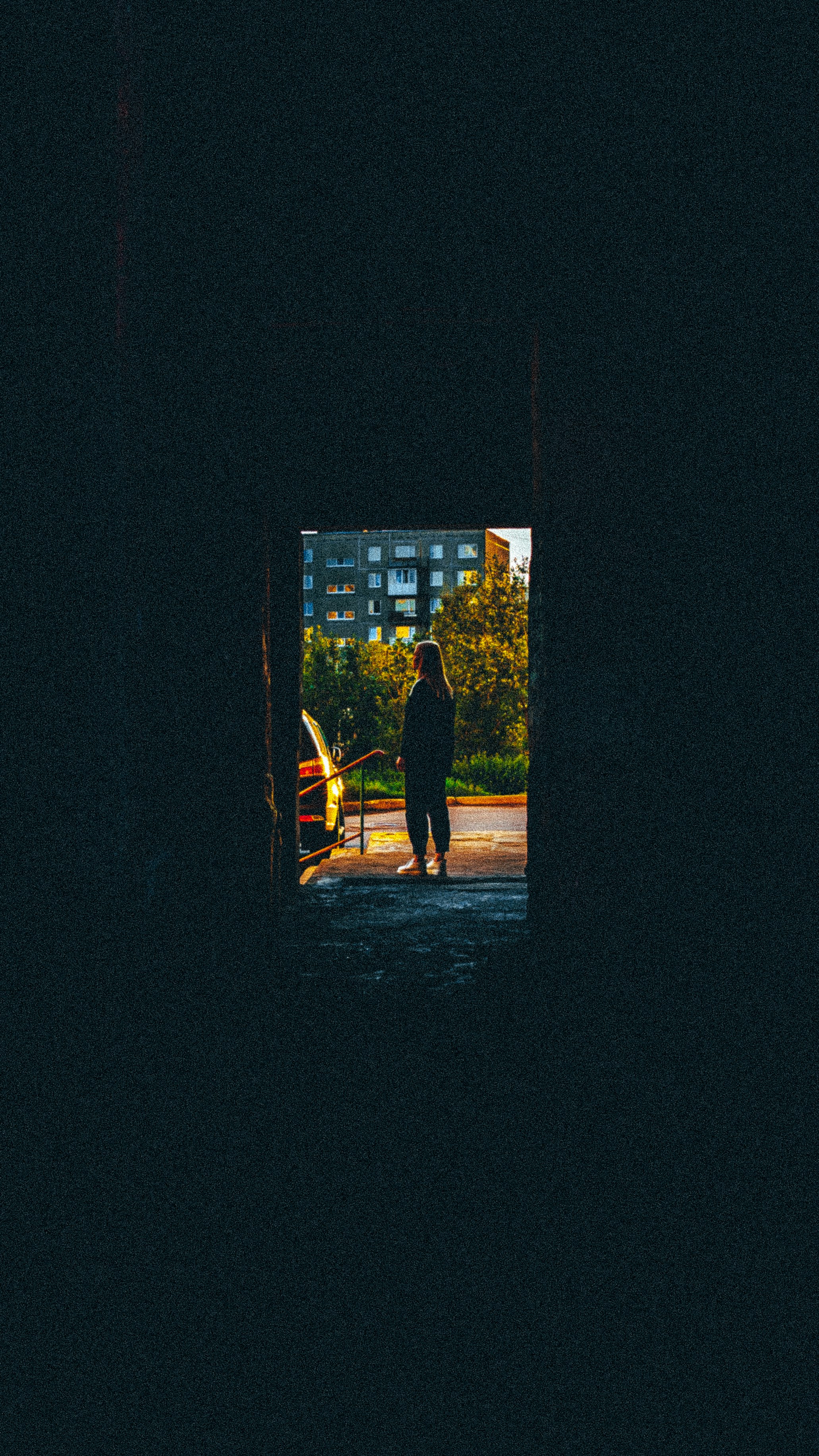 a person standing in a dark tunnel with a skateboard