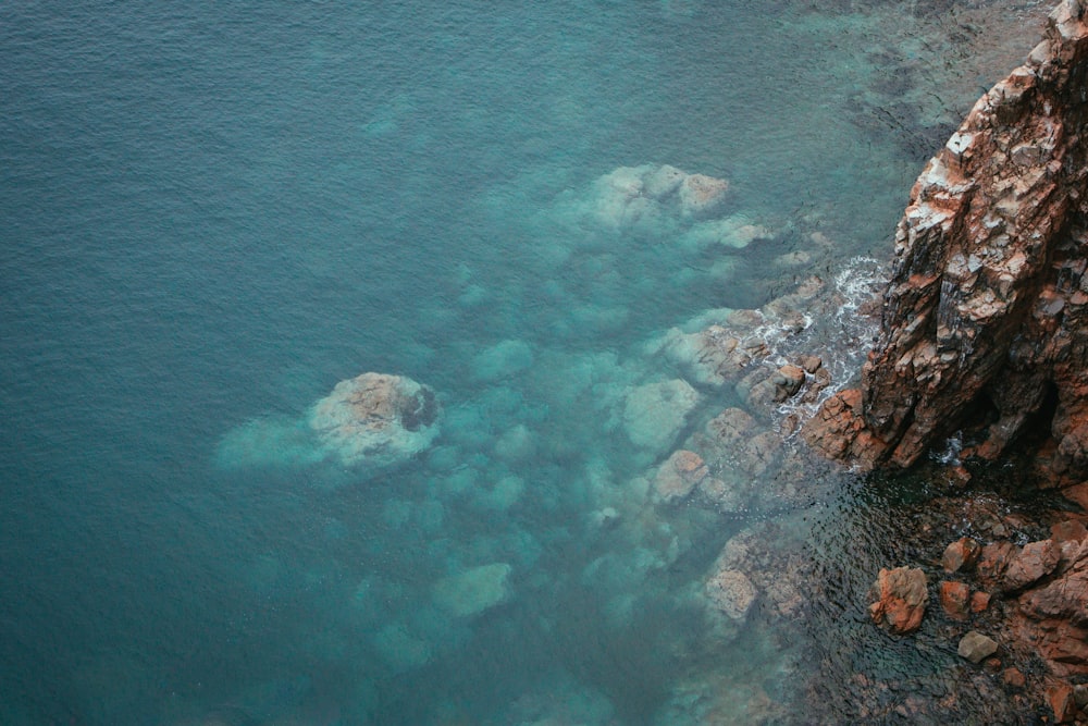 a body of water surrounded by rocks and a cliff