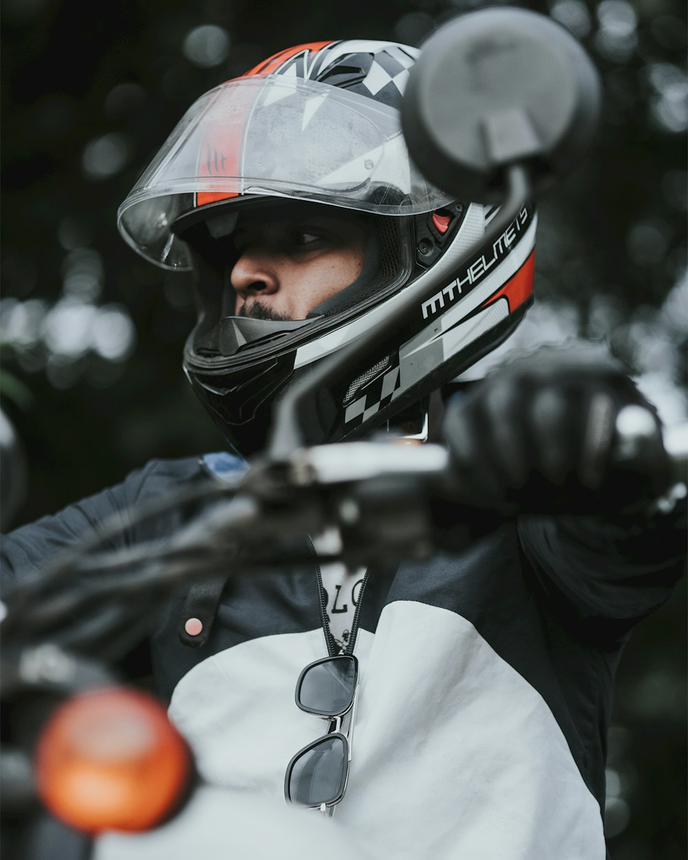 a man wearing a helmet and holding onto a motorcycle