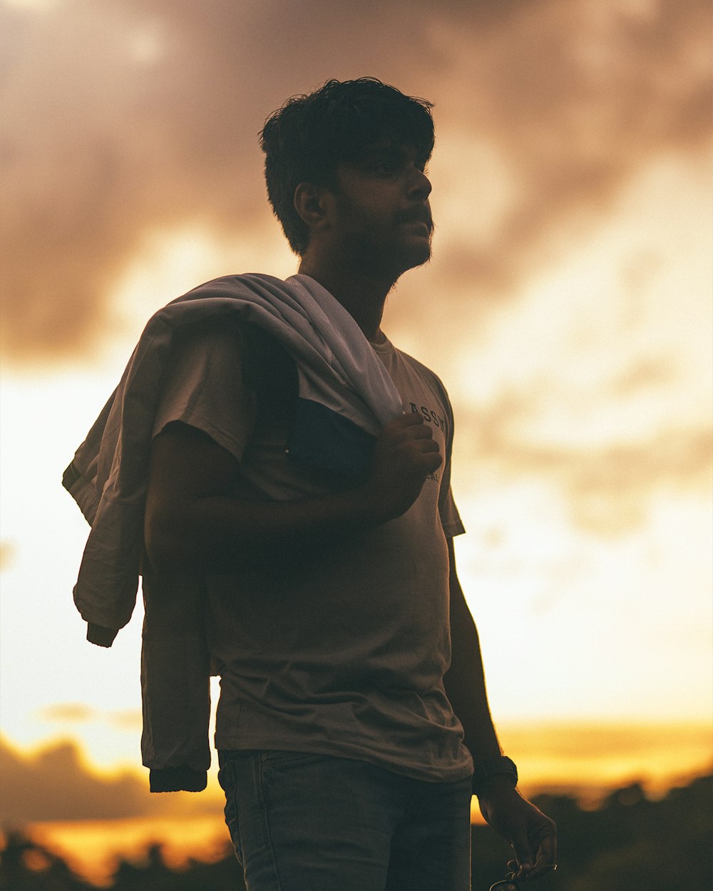 a man standing in front of a cloudy sky