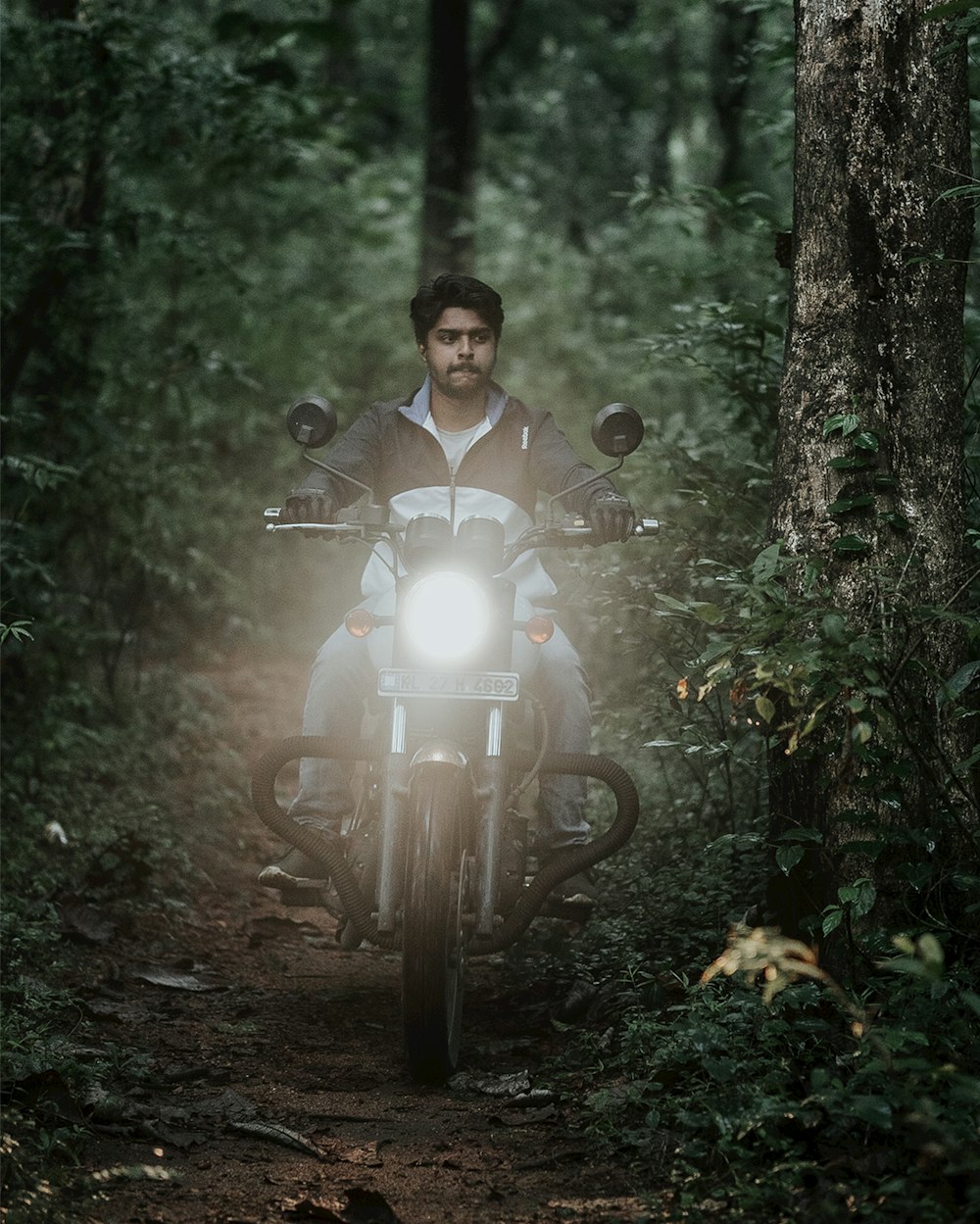 Un hombre conduciendo una motocicleta a través de un bosque