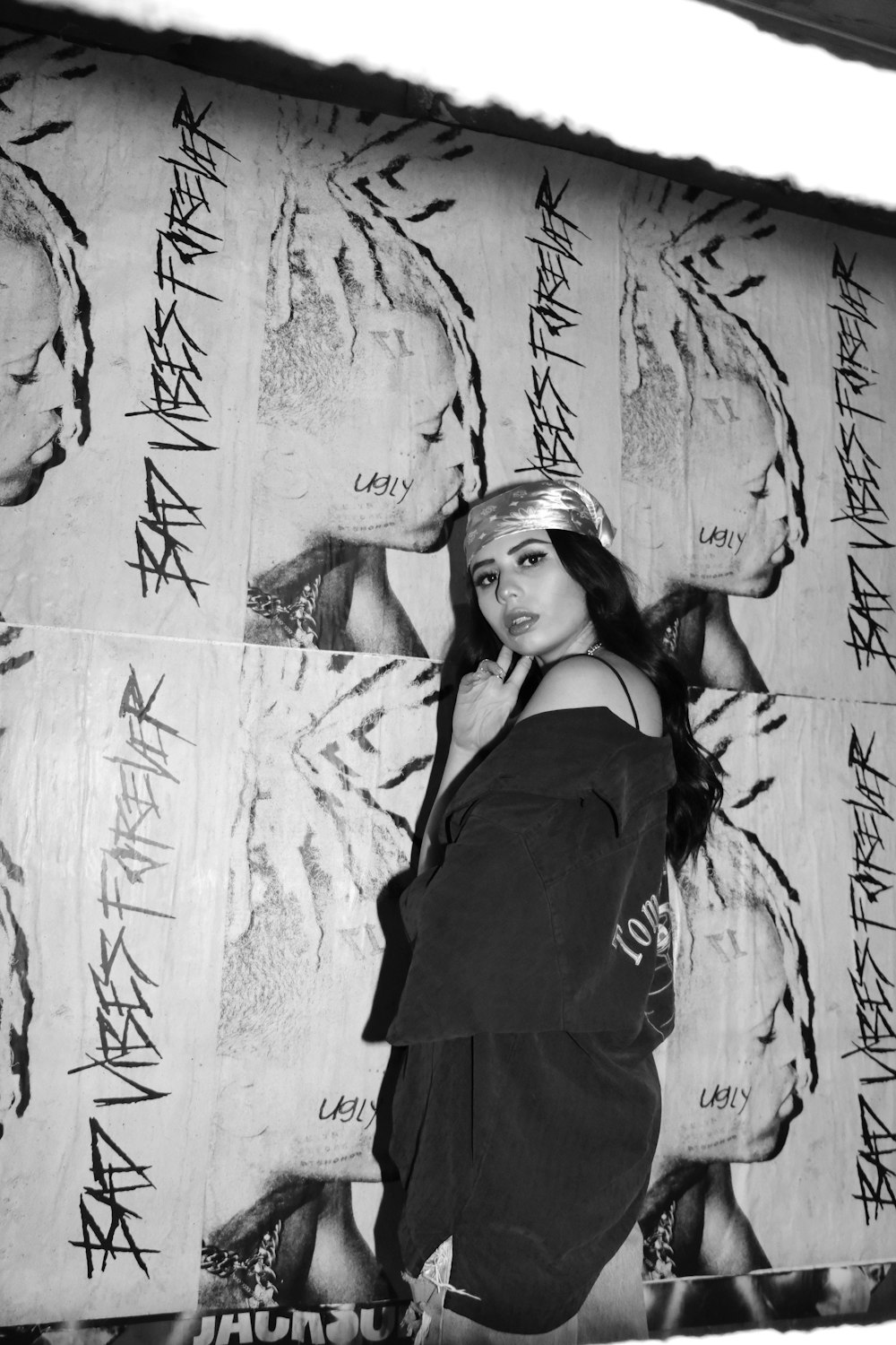 a woman standing in front of a wall covered in graffiti