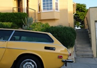 a yellow car parked in front of a house