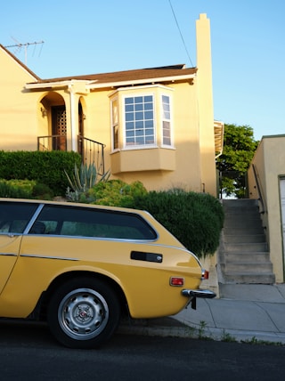 a yellow car parked in front of a house
