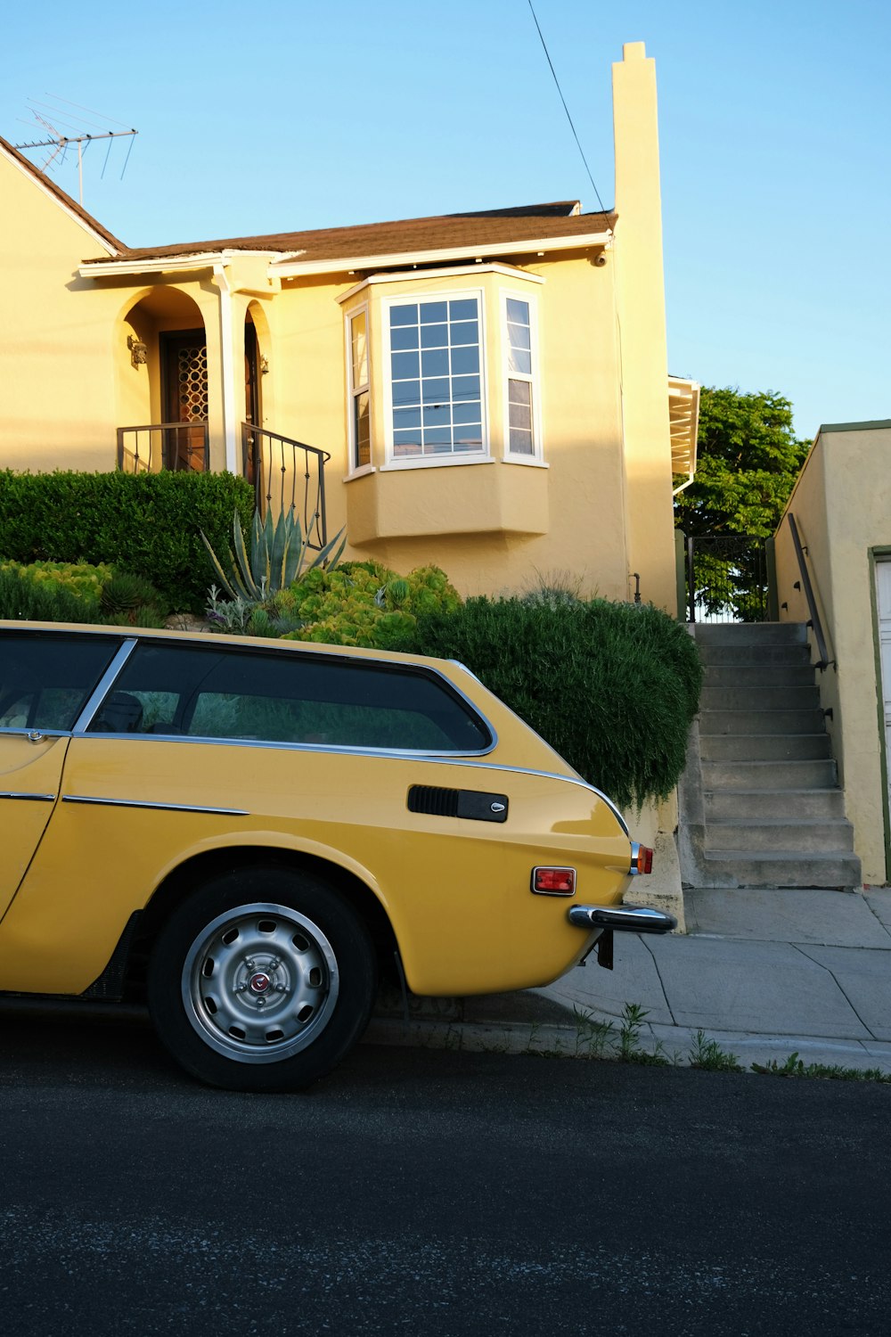 a yellow car parked in front of a house