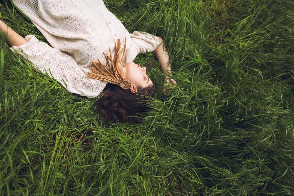 a woman laying in a field of tall grass