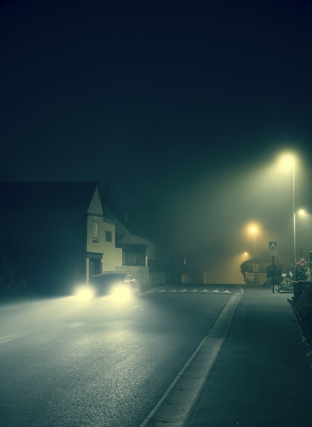 a car driving down a street at night