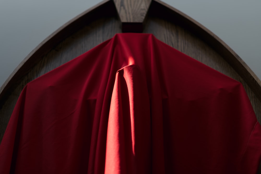 a close up of a red cloth on a wooden structure