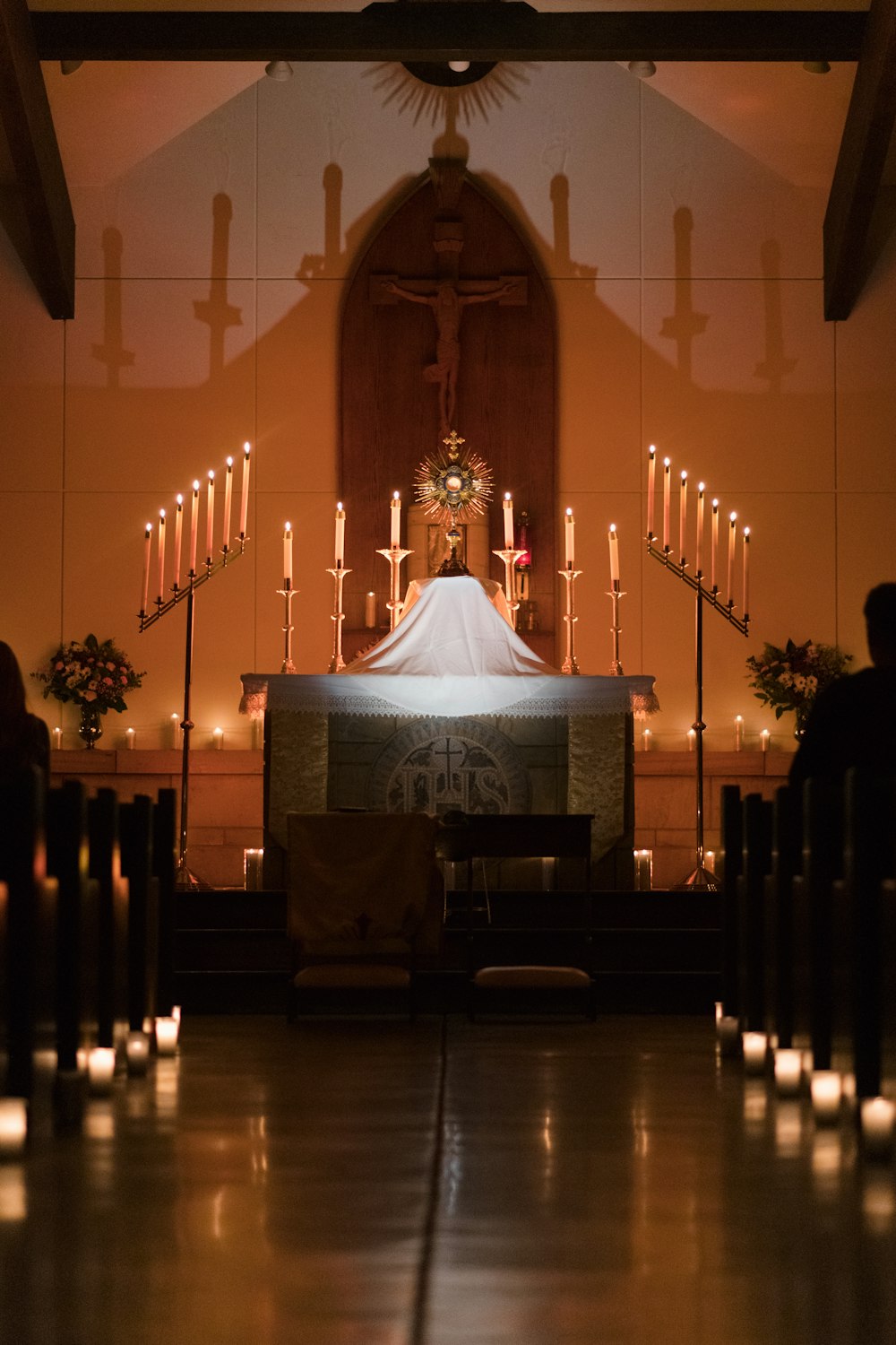 a church with candles lit up in front of the alter