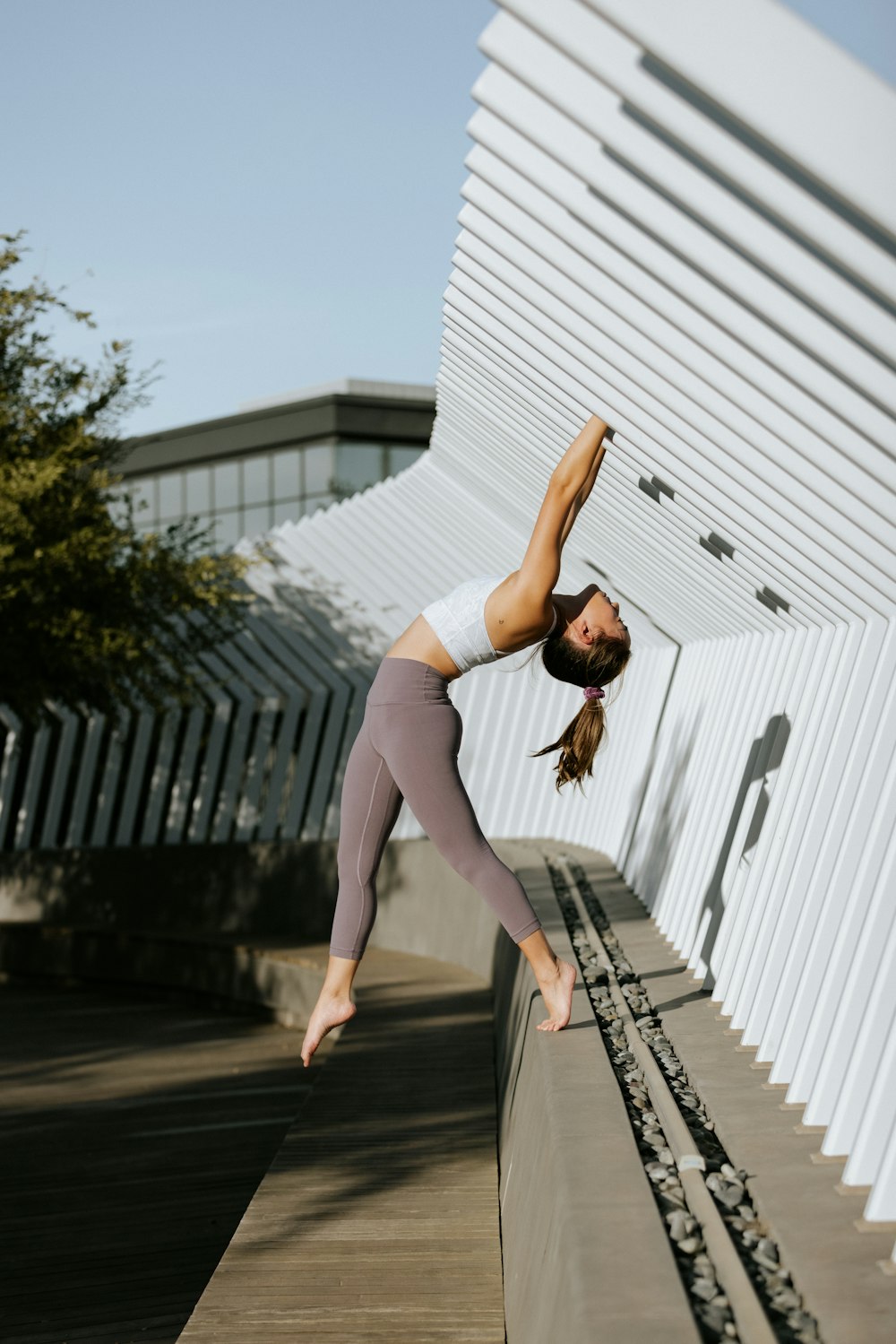 a woman doing a hand stand on a wall