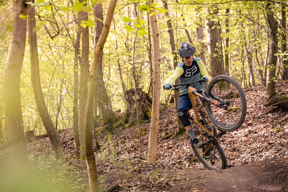 a man riding a mountain bike through a forest