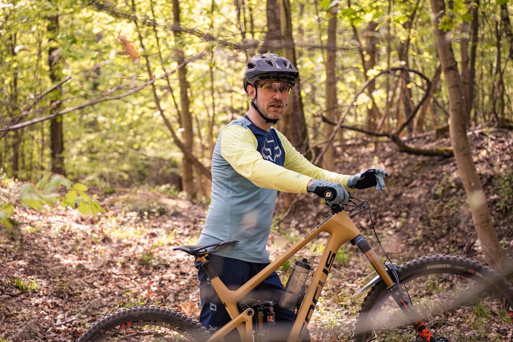 a man riding a bike through a forest