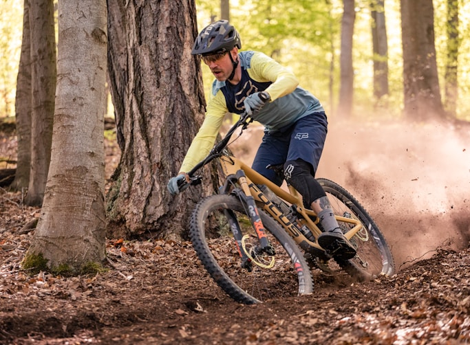 a man riding a mountain bike through a forest