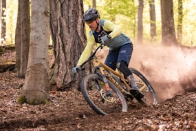 a man riding a mountain bike through a forest