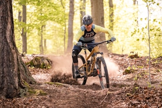 a man riding a mountain bike through a forest