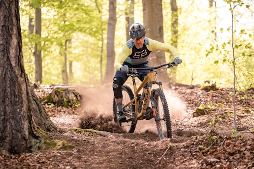 a man riding a mountain bike through a forest
