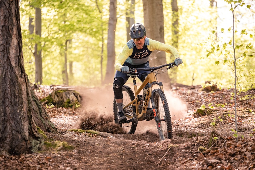 a man riding a mountain bike through a forest