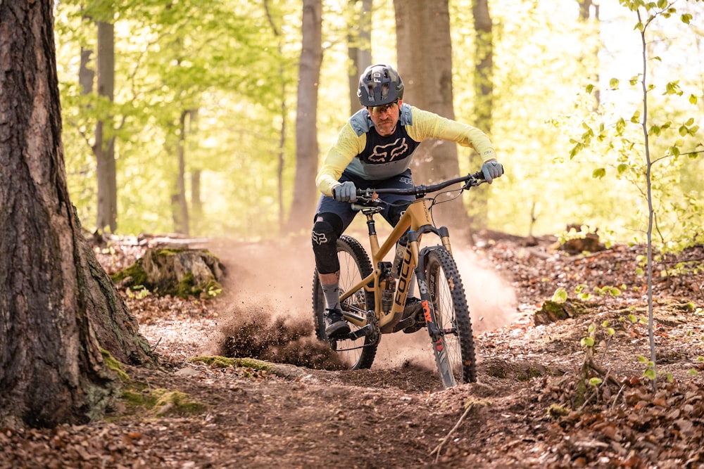 a man riding a mountain bike through a forest