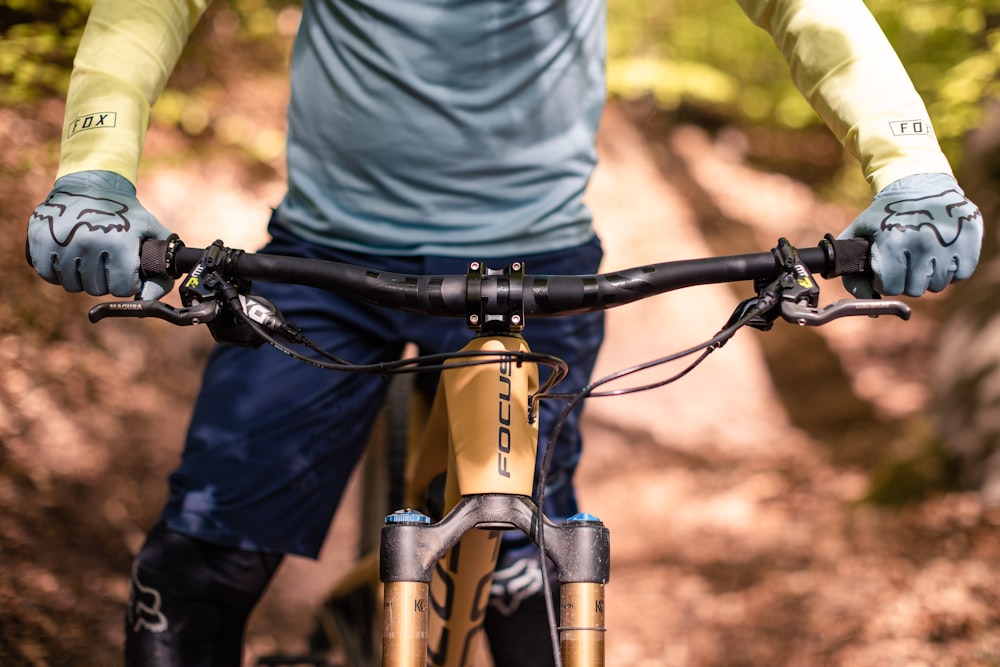 a close up of a person riding a bike on a trail