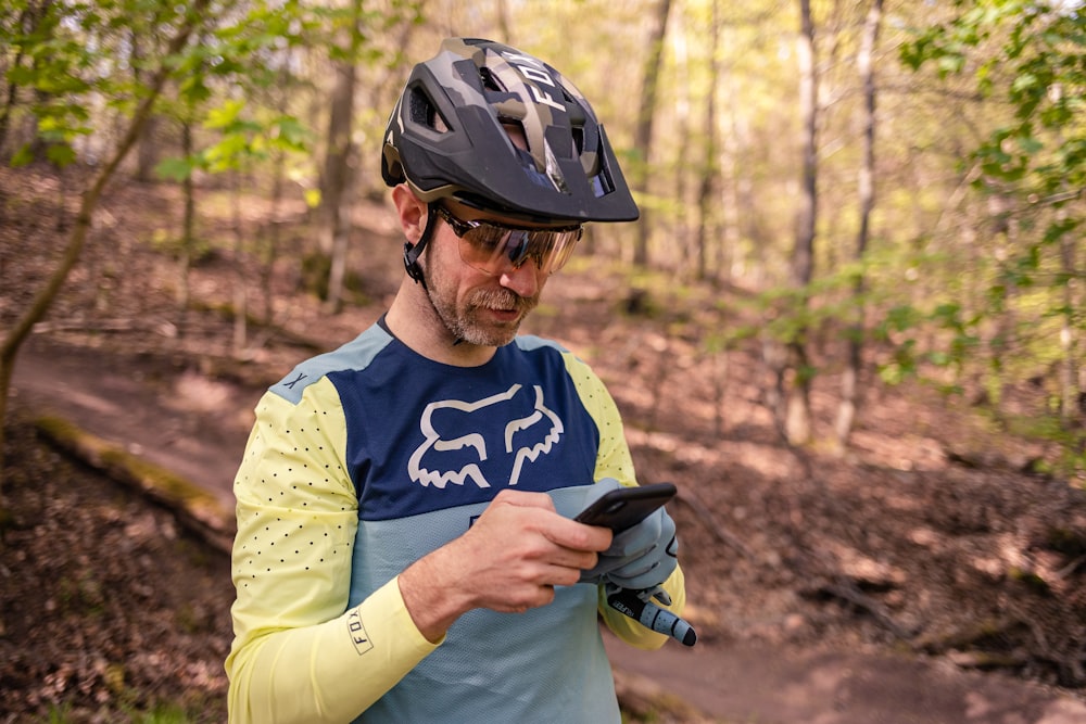 a man wearing a helmet looking at his cell phone