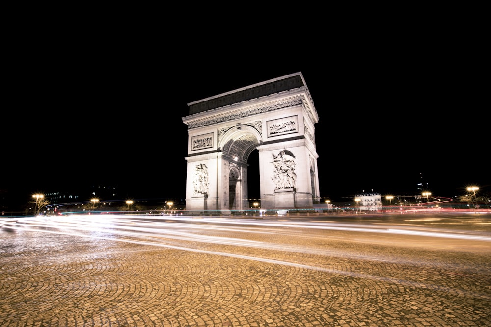 a night shot of the arc of triumph in paris