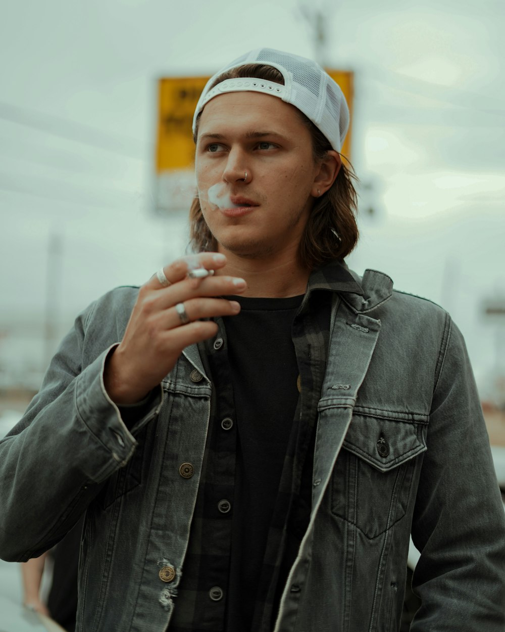 a young man smoking a cigarette on the street