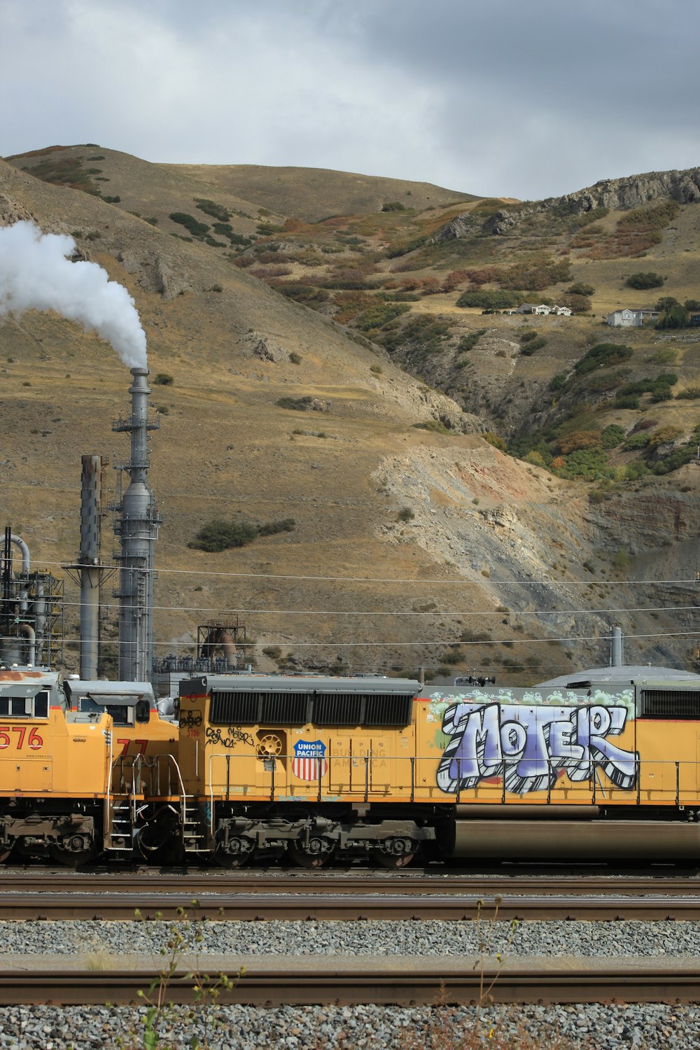 a yellow train with graffiti on the side of it