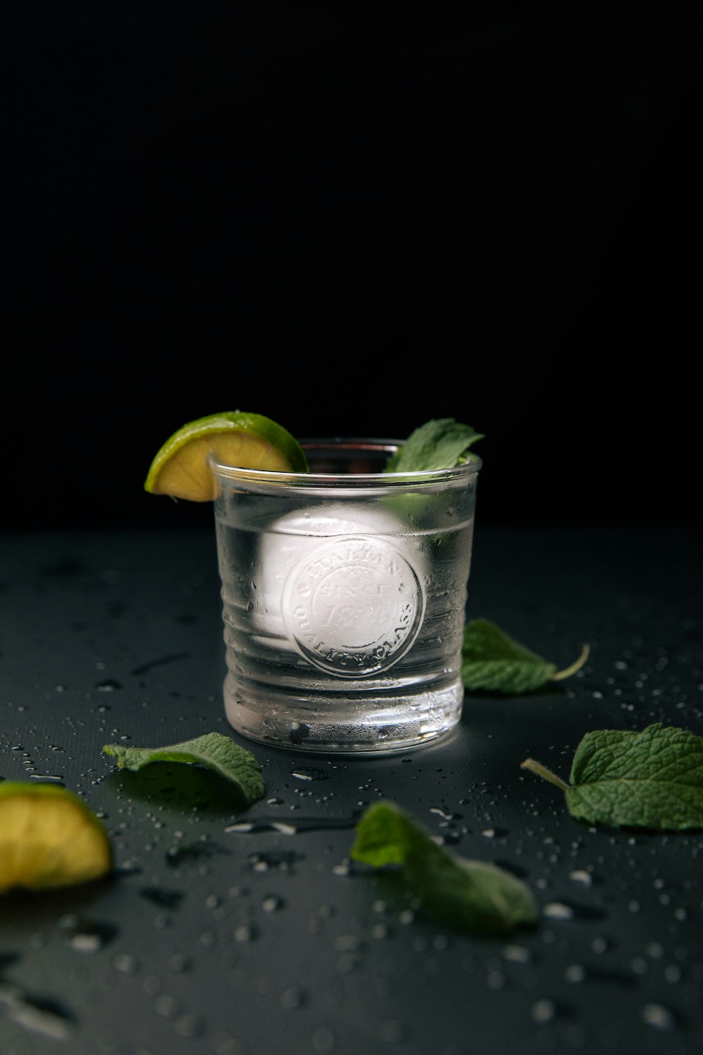 a shot glass filled with water and limes