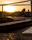 Cinematic view of a premium boat anchored in turquoise waters with a sunset backdrop
