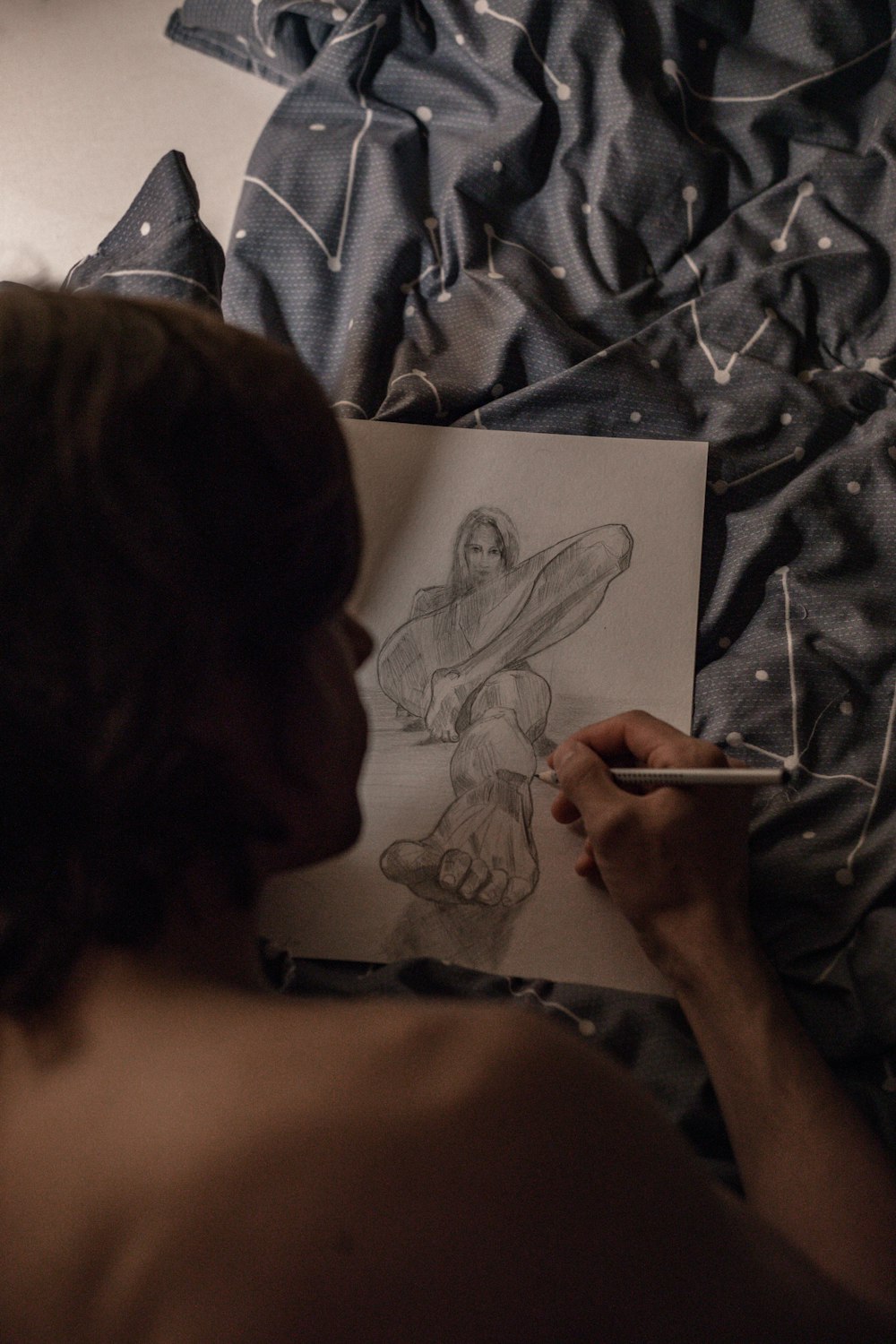 uma mulher está desenhando uma imagem em uma folha de papel
