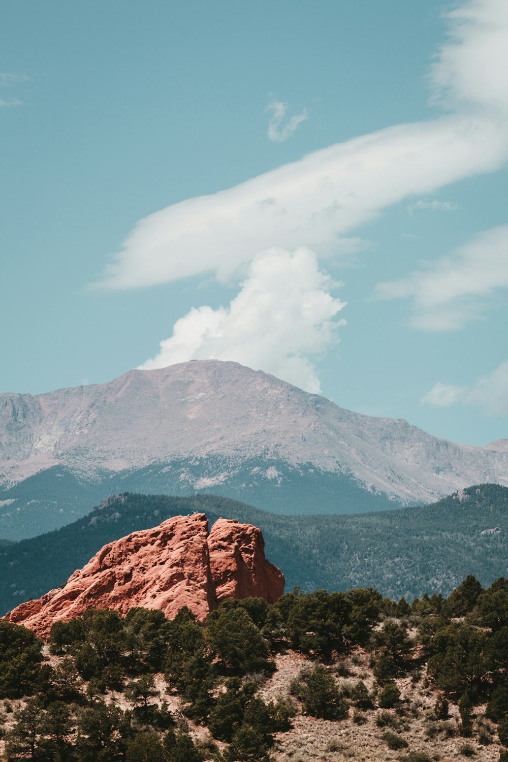 a view of a mountain range with trees and mountains in the background