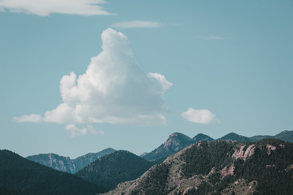 a view of a mountain range with a cloud in the sky