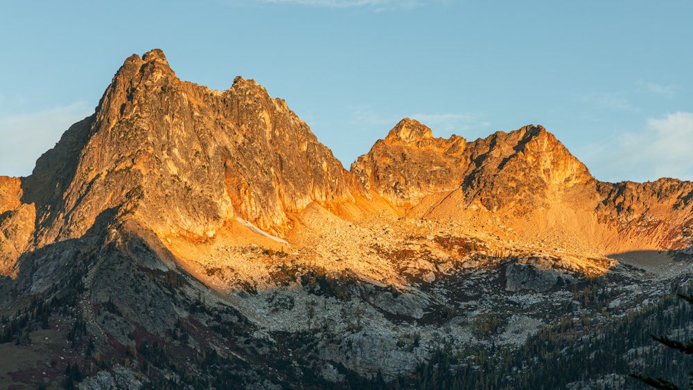 the sun is setting on a mountain peak