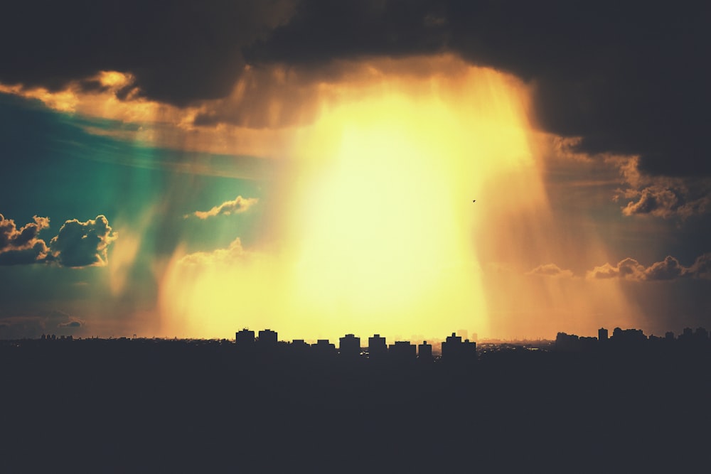 the sun shining through the clouds over a city