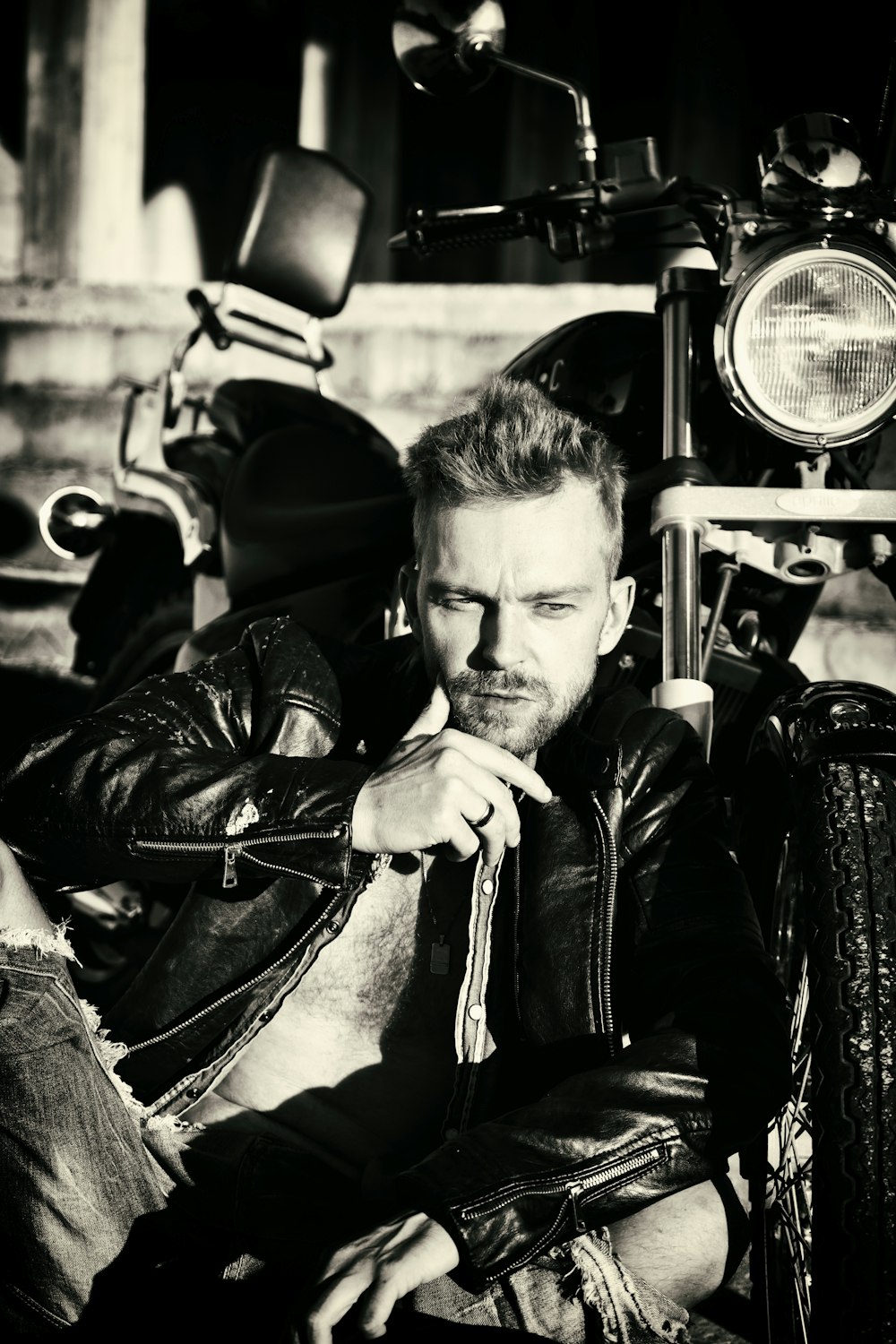 a black and white photo of a man sitting on a motorcycle