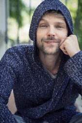a man with a hoodie on sitting down