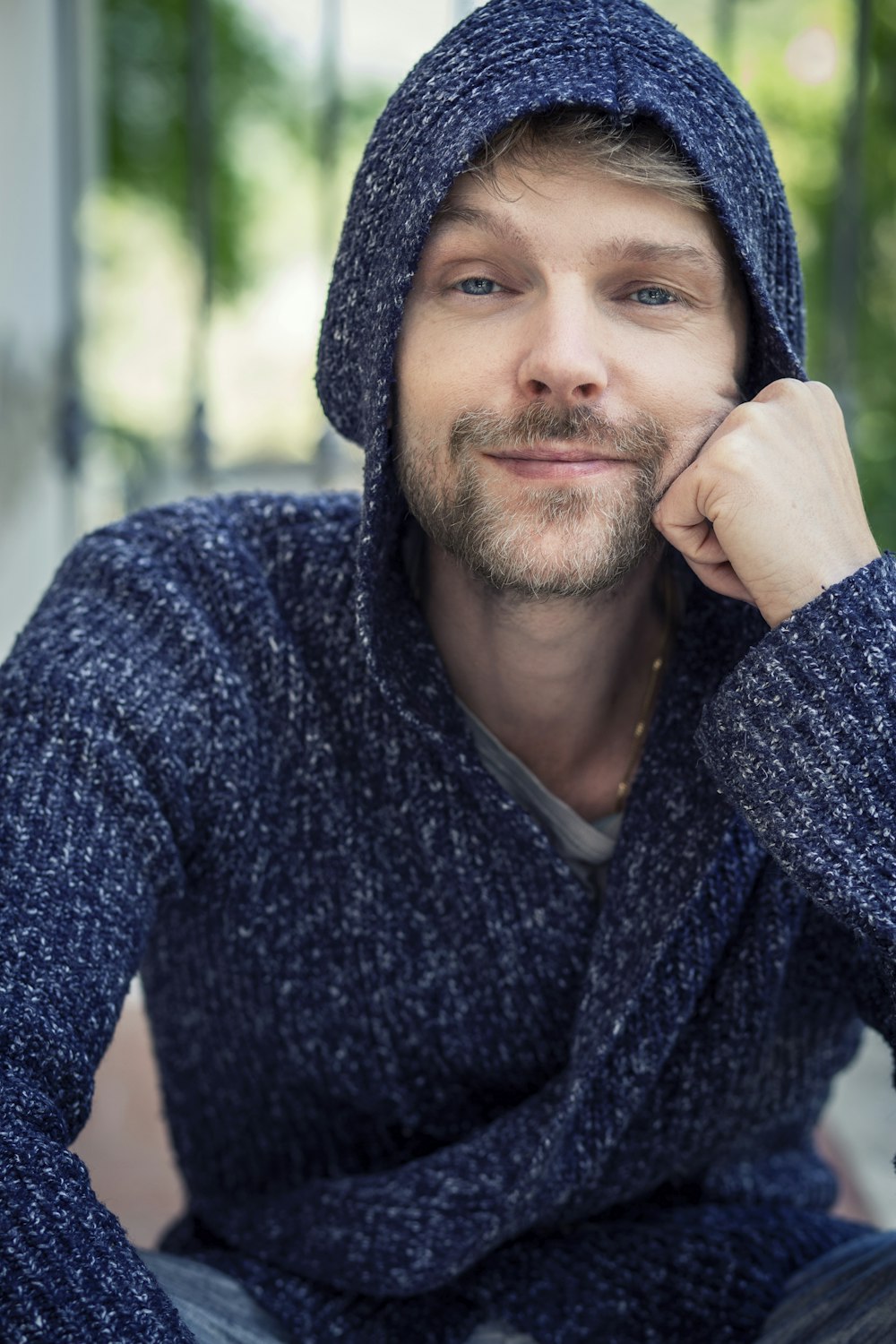 a man with a hoodie on sitting down