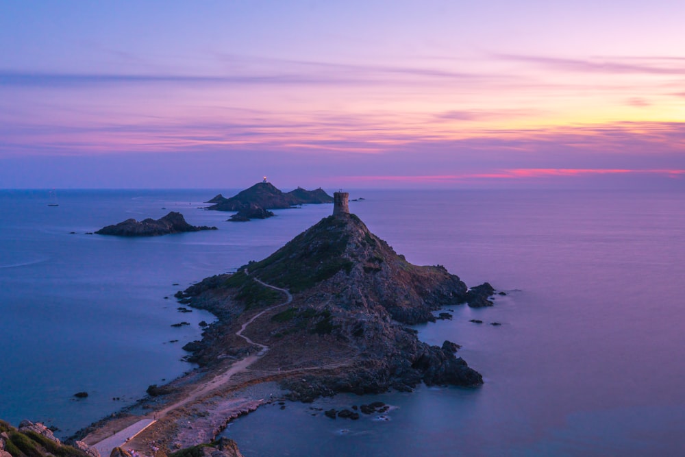 a lighthouse on a small island in the middle of the ocean