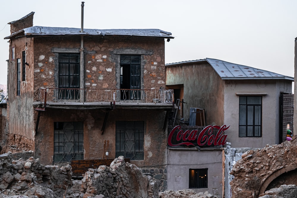 um prédio antigo com um sinal de coca-cola nele