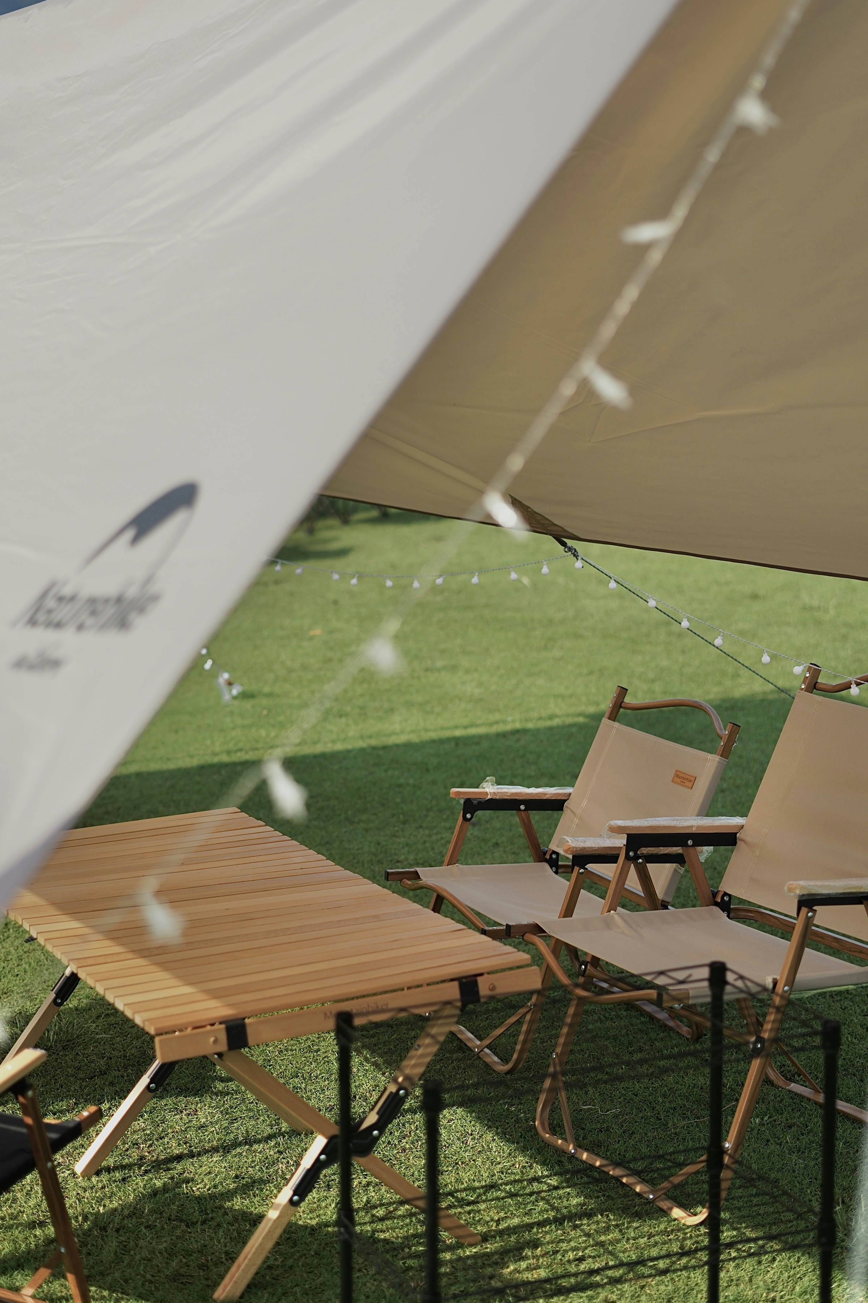 a couple of chairs sitting under a white umbrella