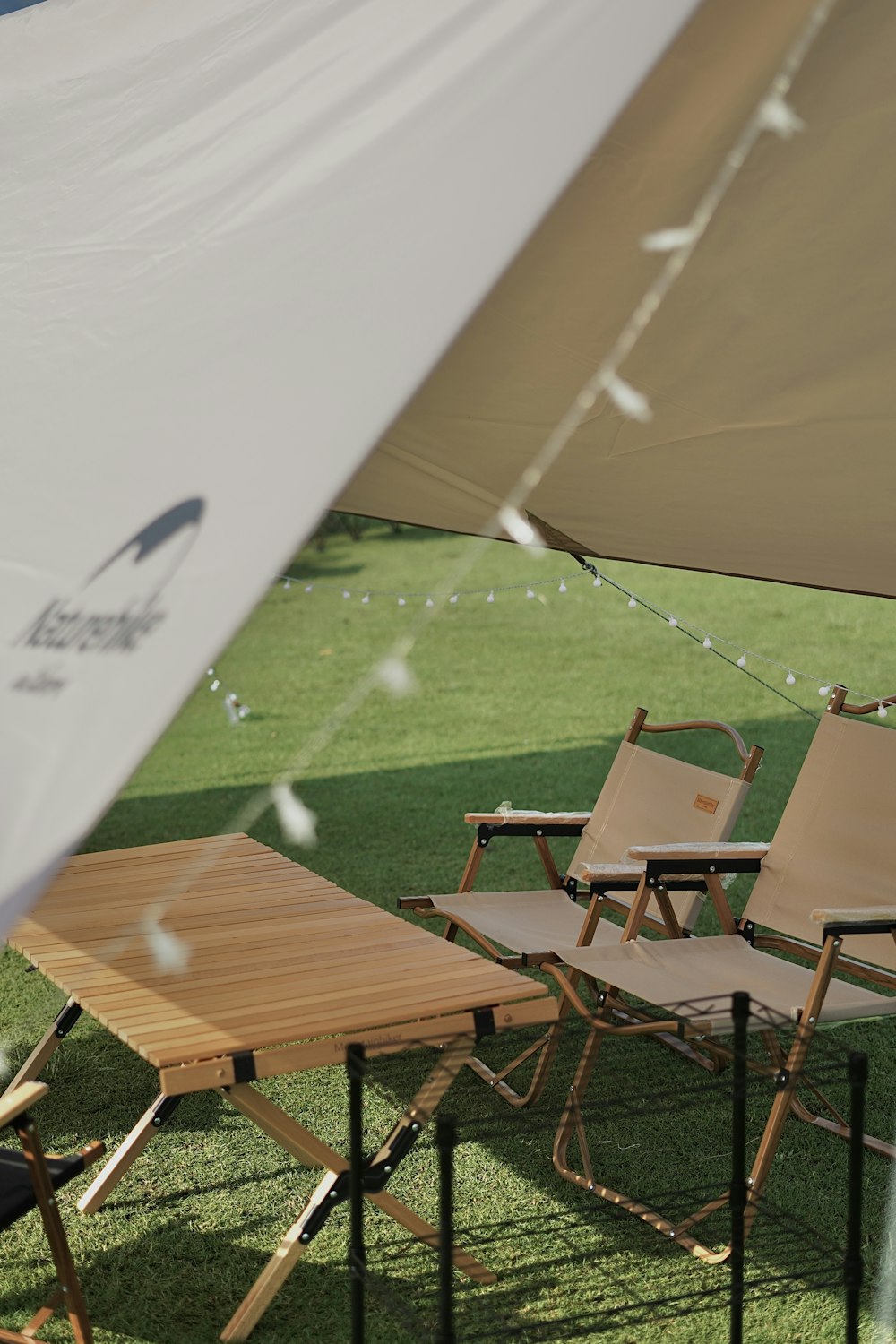 a couple of chairs sitting under a white umbrella