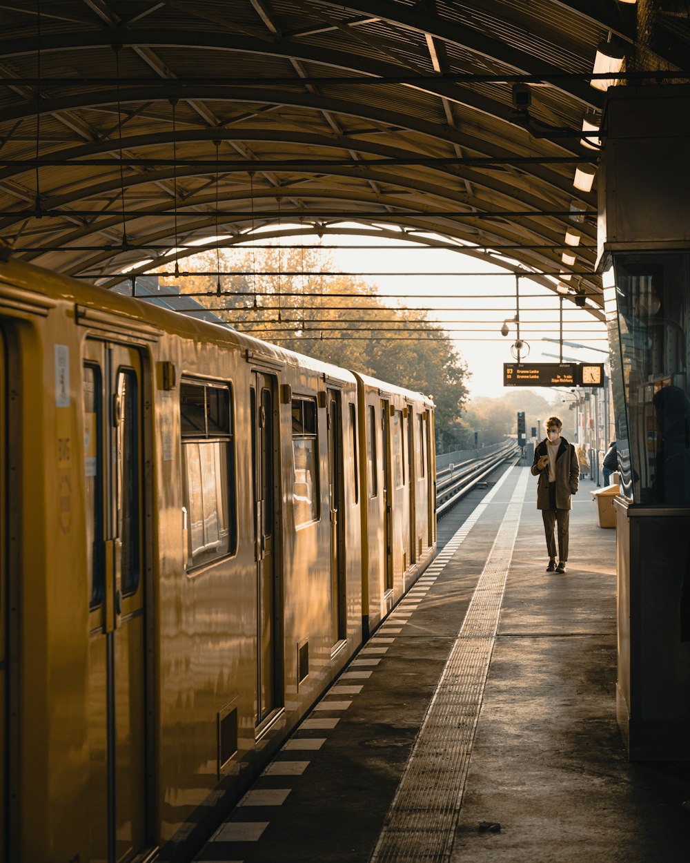 Ein Mann geht auf einem Bahnsteig neben einem Zug