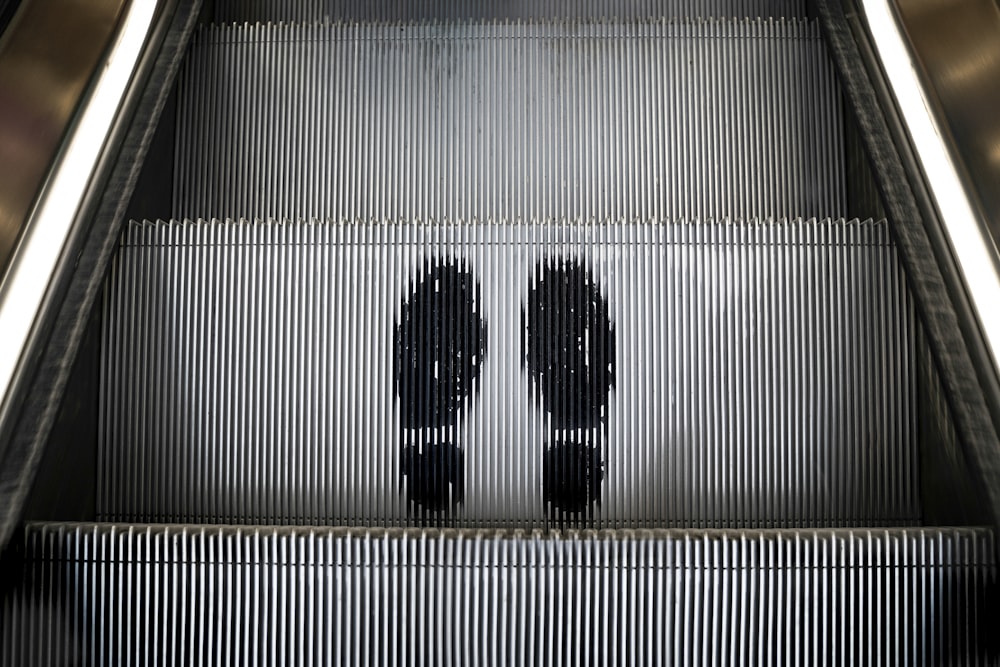 Un par de personas bajando por una escalera mecánica