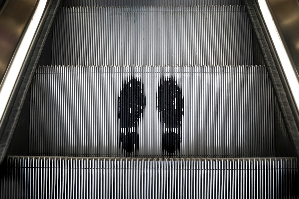 a couple of people riding down an escalator