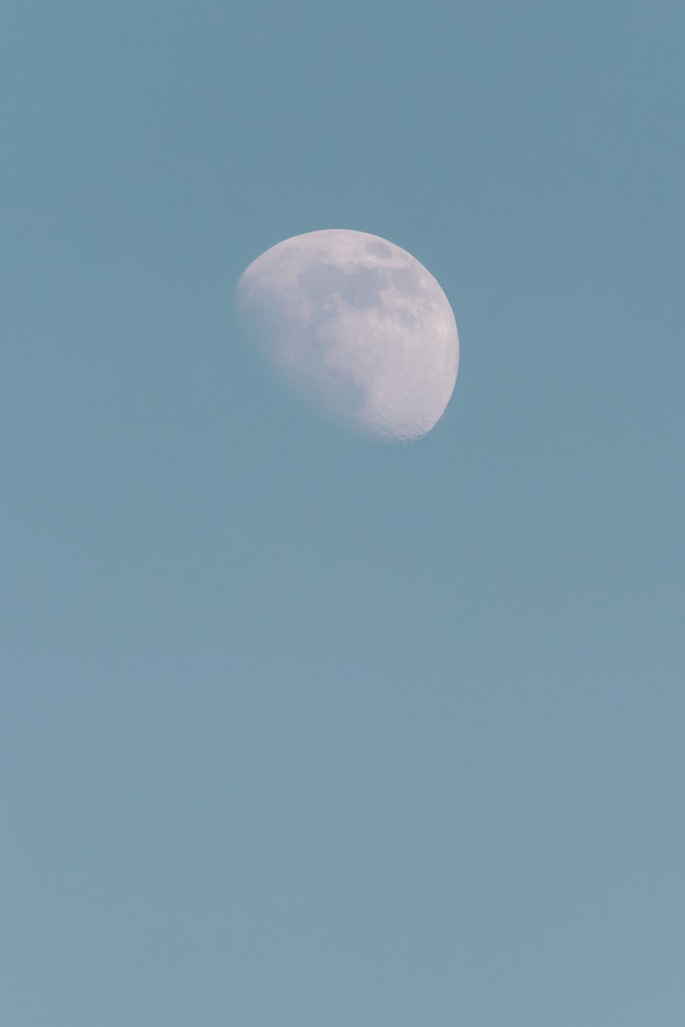 a plane flying in the sky with the moon in the background