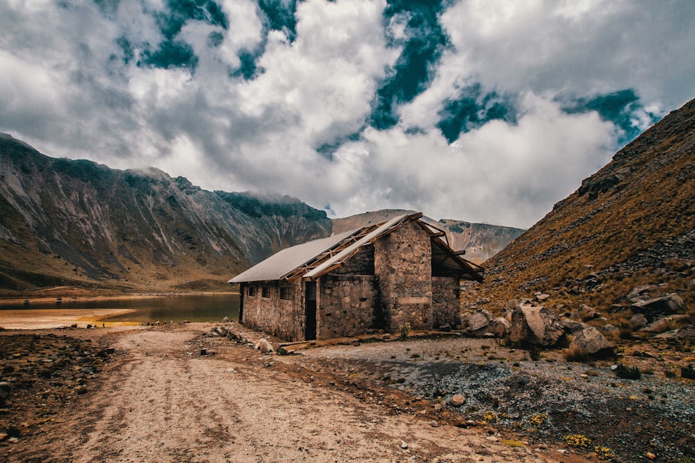 a small building sitting on the side of a dirt road