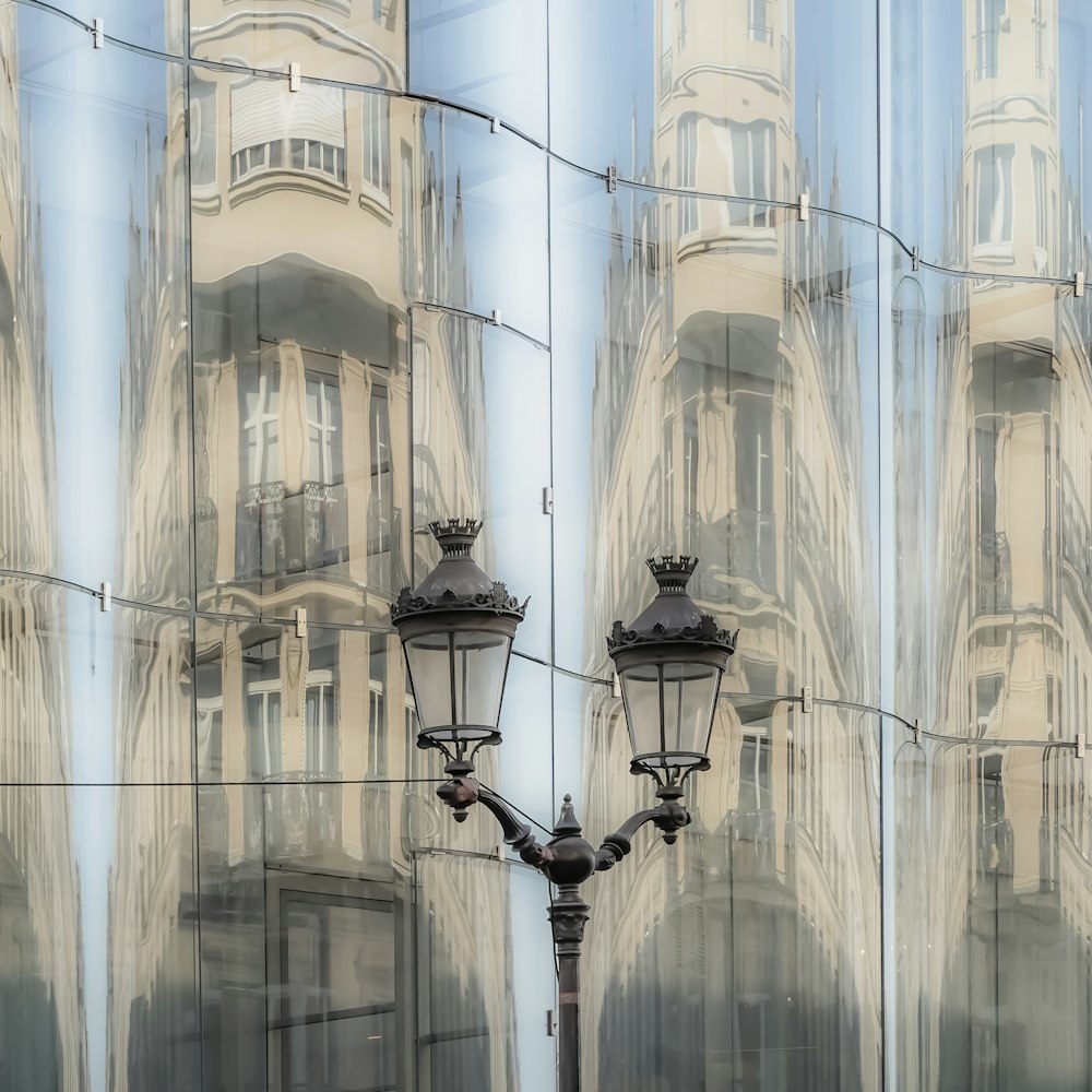 a street light in front of a mirrored building