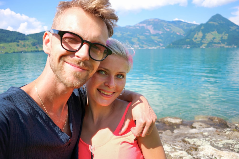 a man and a woman standing next to each other near a body of water