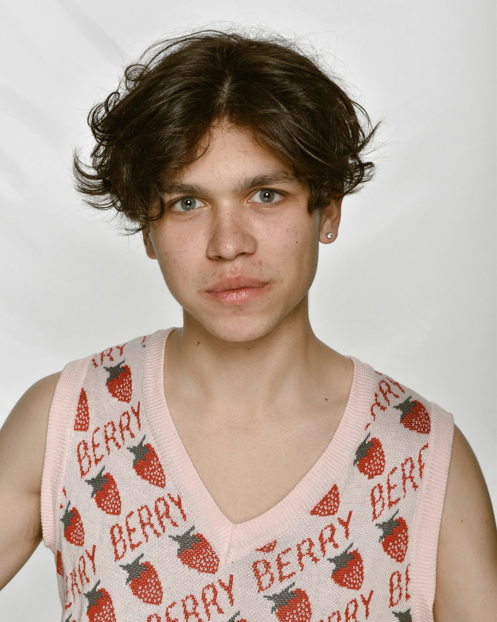 a young man wearing a pink shirt with strawberries on it