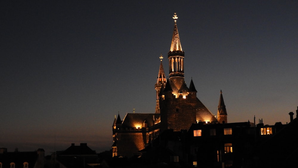 Ein Gebäude mit einem nachts beleuchteten Kirchturm